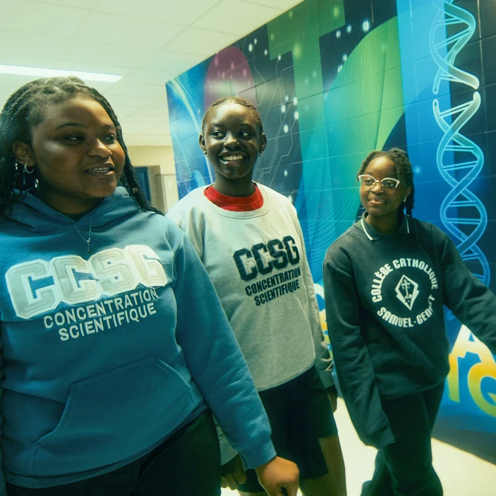 trois élève marchant d'un pas déterminé dans le couloir de l'école