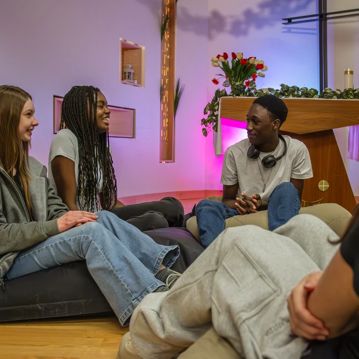 Des élèves discutent ensemble dans une chapelle d'école.